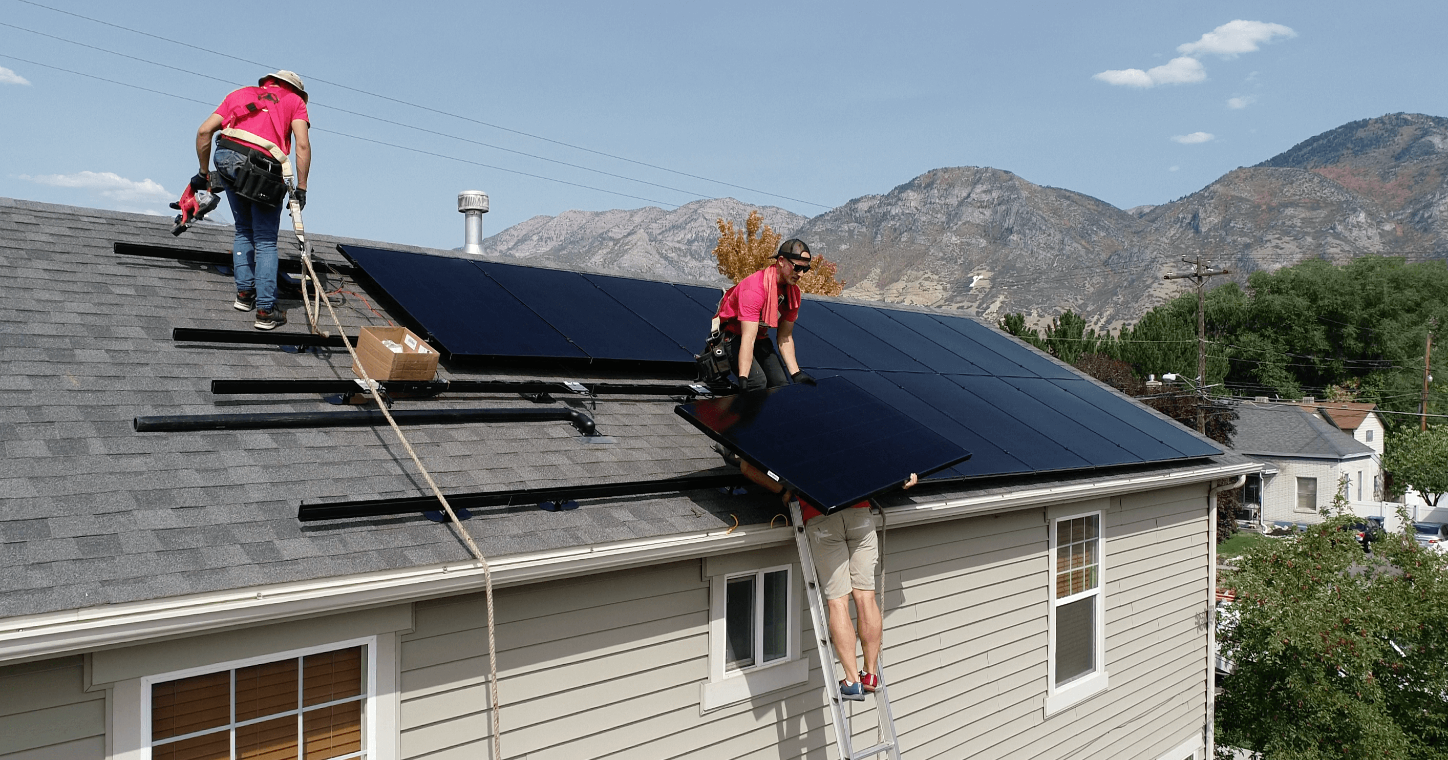 Solar installers on roof of home installing solar panels